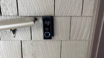 A door with a textured wooden panel design and a modern electronic lock system.