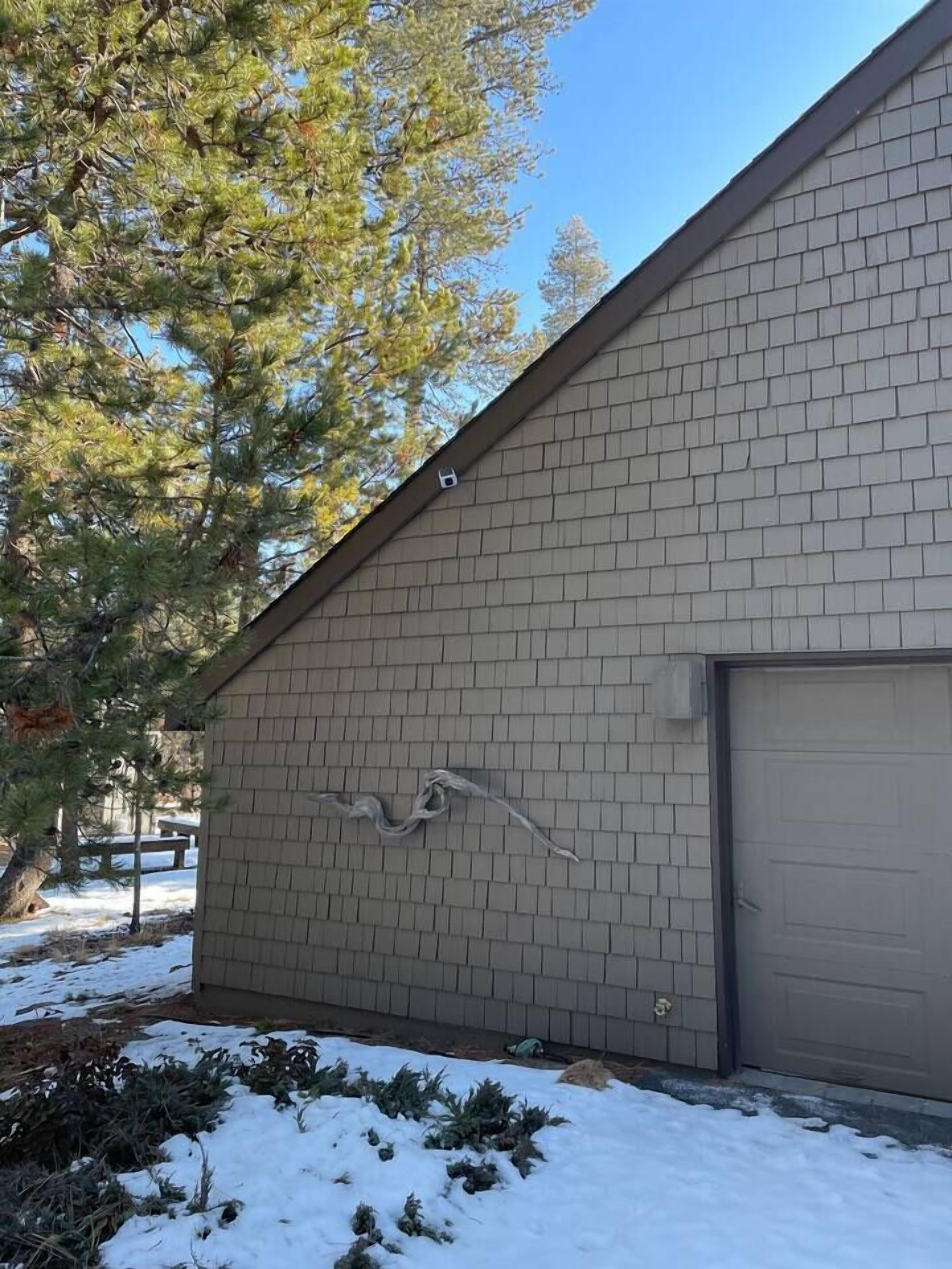 A building with a sloped roof and a garage door.