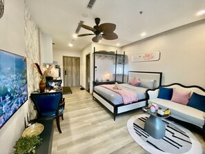 A modern bedroom with a bed, a sofa, a coffee table, and a TV. - Friendly House QMP - Ecopark (Van Giang)