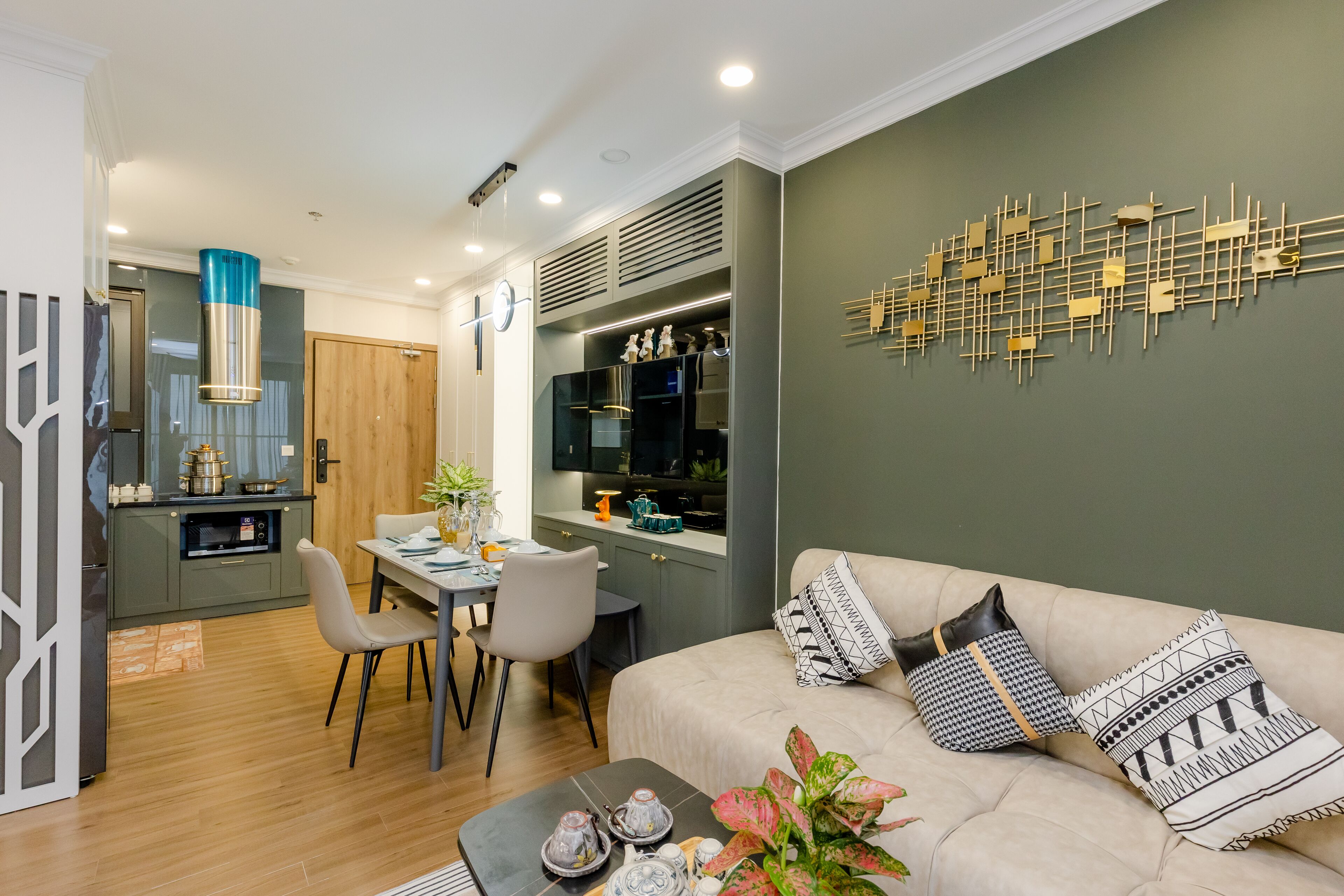 A modern living room with a sofa, a dining table, and a kitchen area.