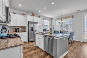 Enjoy cooking in this well-equipped kitchen with a central island, dishwasher, and stainless steel appliances.
