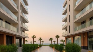 Un couloir d’hôtel moderne offrant une vue sur la mer au coucher du soleil.