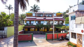 A two-story building with a red and yellow facade, a balcony, and a scooter parked in front. - Mermaid  Island Beach Resort (Vanur)