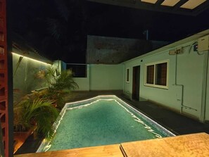 A swimming pool with a tiled edge and a wooden deck in front. - Mermaid  Island Beach Resort (Vanur)