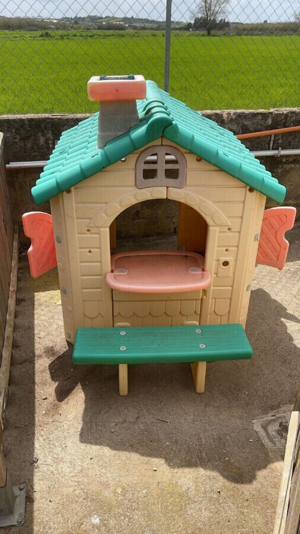 A children's playhouse with a green roof, a pink bench, and a small entrance. - Sa Canova - relax in Mallorca (Illes Balears)