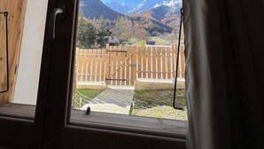 A room with a wooden ceiling and a large window. - Superbe Appartement Chalet Pieds des Pistes et des Bains (Le Monêtier-les-Bains)