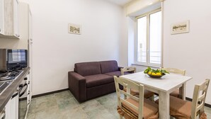 Une cuisine compacte équipée d’une cuisinière, d’un four et d’un coin repas avec une table et des chaises.