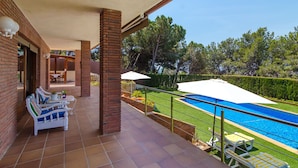 A covered patio with a pool, outdoor furniture, and a view of the surrounding landscape. - Club Villamar - Superbly presented family villa located in one of the most beautiful neighbourhoo... (Lloret de Mar)