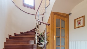 A wooden staircase with a metal handrail leading to a door with frosted glass panels. - Club Villamar - Superbly presented family villa located in one of the most beautiful neighbourhoo... (Lloret de Mar)