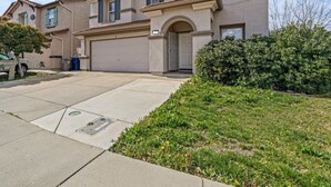 Un immeuble résidentiel à deux étages, doté d’un garage, d’une allée et d’une pelouse bien entretenue.