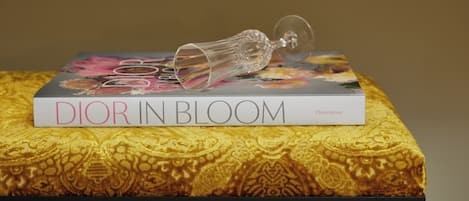 A book titled 'DIOR IN BLOOM' with a floral design on the cover, placed on a patterned box.
