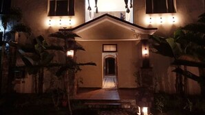 A two-story house with a central entrance, illuminated by exterior lights. - The Corbett Jungle  (Ramnagar)