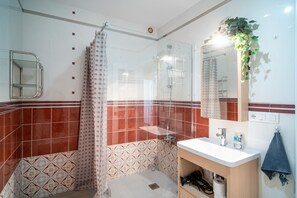Enjoy a refreshing shower in this well-appointed bathroom with a glass-enclosed shower area and sleek sink.