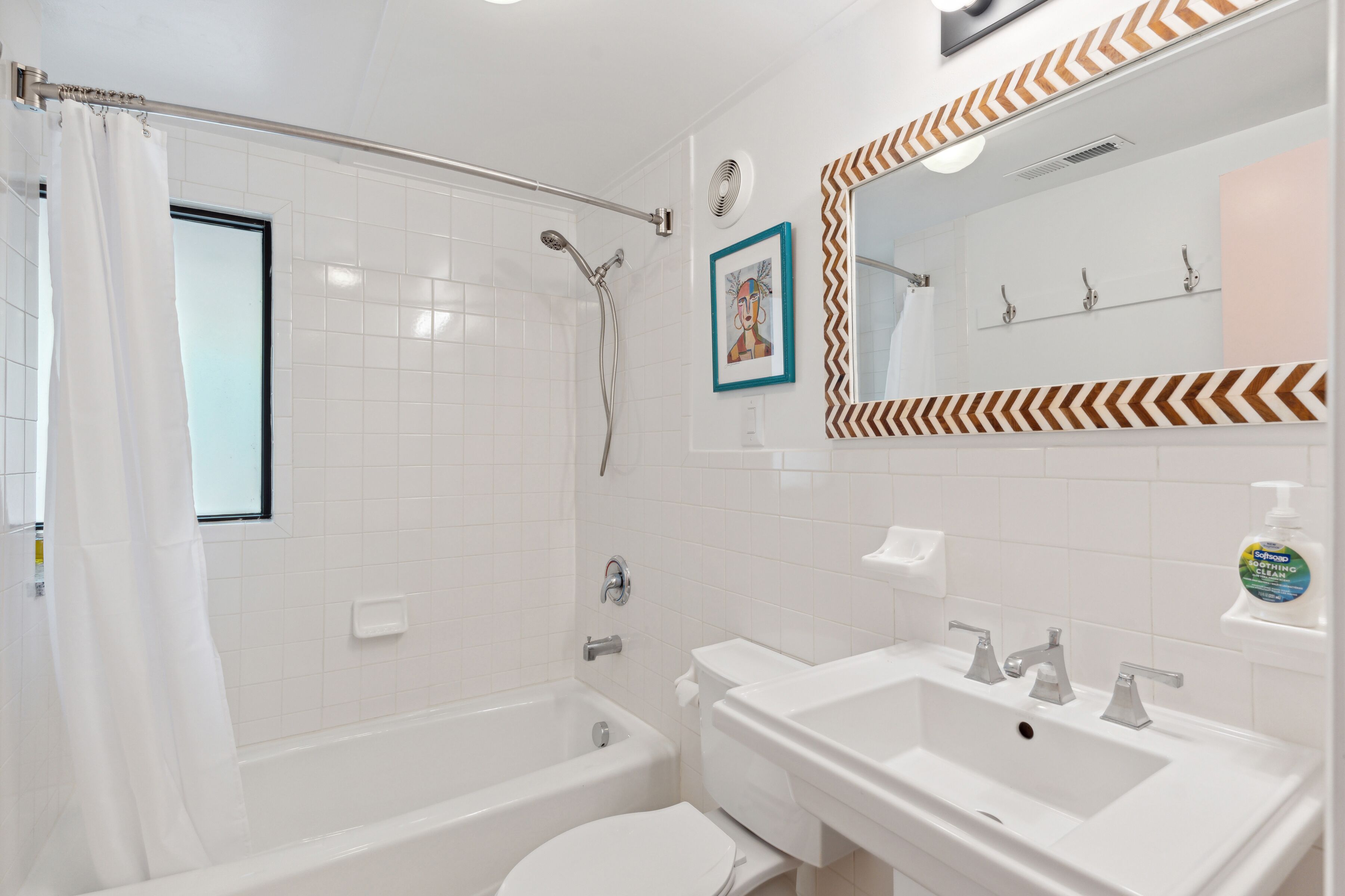 A bathroom with a bathtub, toilet, sink, and shower.