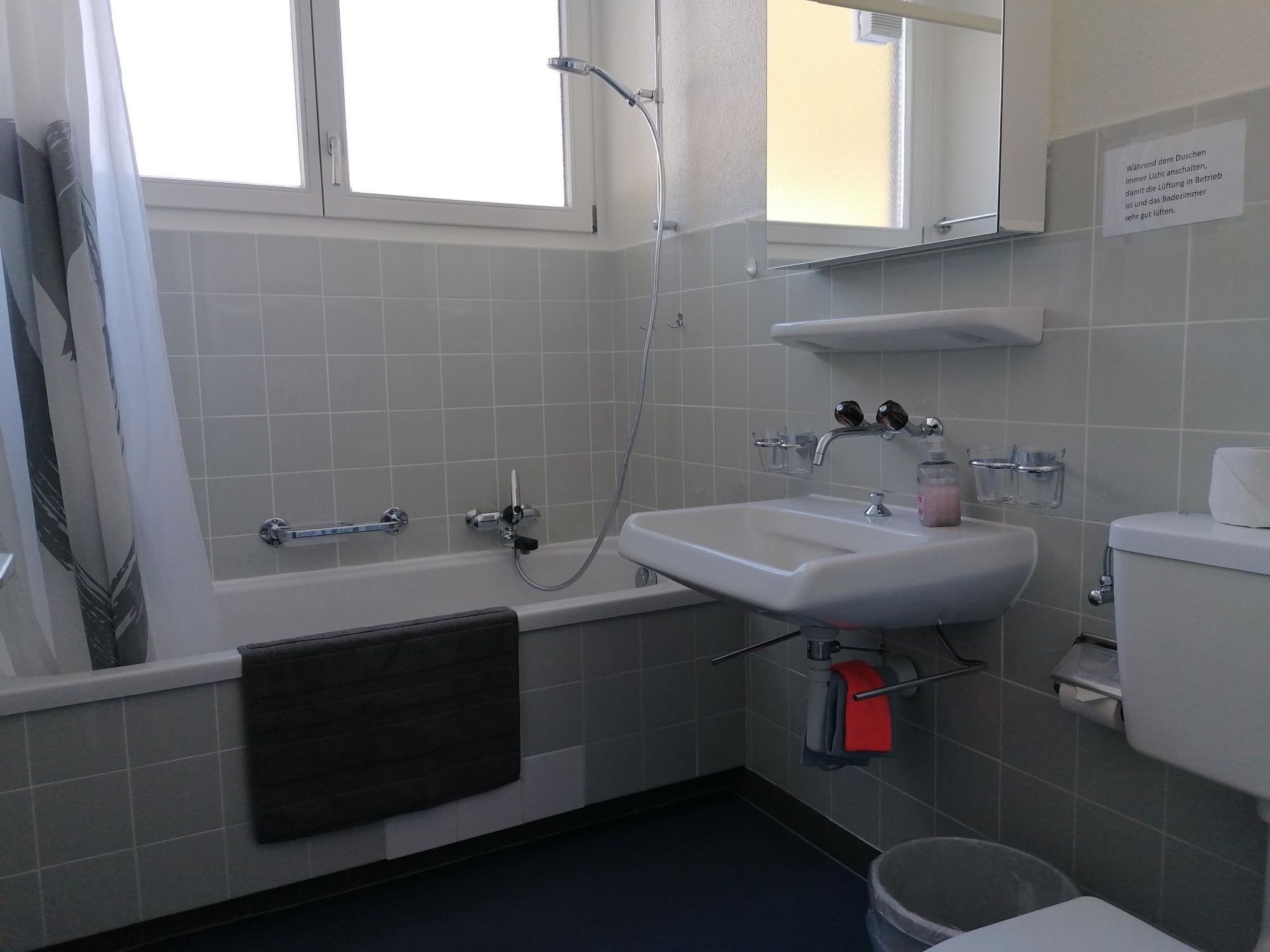 Un bany amb banyera, un lavabo, un vàter i una finestra.