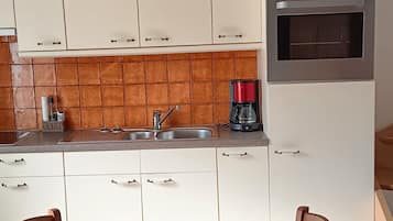 Een koelkast, een oven, een kookplaat, een koffiezetapparaat/waterkoker