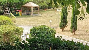 A park with a play area, a covered seating area, and neatly trimmed hedges. - Gîte des Anges, 2 pers. swimming pool, direct access to the river La Méouge (Barret-sur-Méouge)
