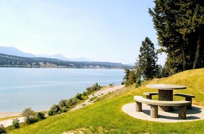 Enjoy a serene lakeside escape with a peaceful picnic spot surrounded by lush greenery and rolling hills.