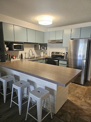 Enjoy cooking in this well-lit kitchen with a large island and stainless steel appliances.