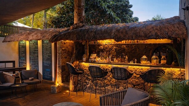 An outdoor bar area with stone walls, thatched roof, and seating. - Sous le Badamier Boutique Hotel & Spa (Grand-Baie)