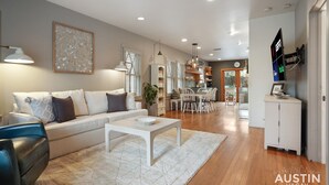 A modern living room with a sofa, coffee table, and dining area.