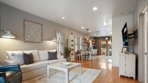 A modern living room with a sofa, coffee table, and dining area. - Shoal Crest xxxxxxxx (Austin)