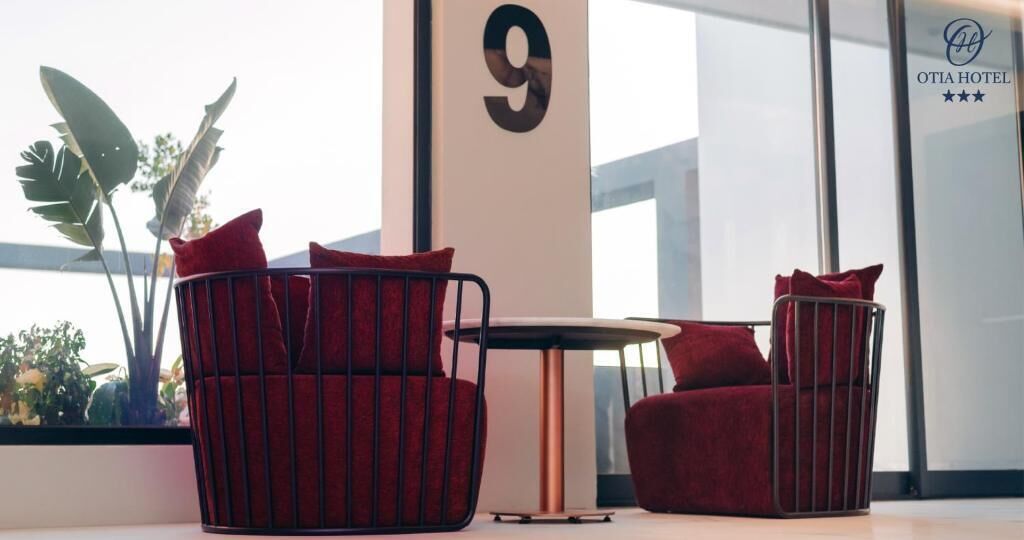 A modern hotel room with a large window, a number 9 sign, and a view of the outdoors.