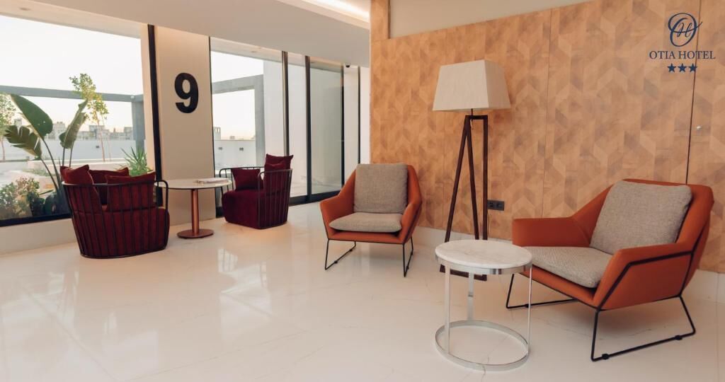 A modern hotel lobby with a large window, a number '9' sign, and a lamp.