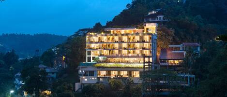 A multi-story hotel with a modern design, featuring balconies and large windows.