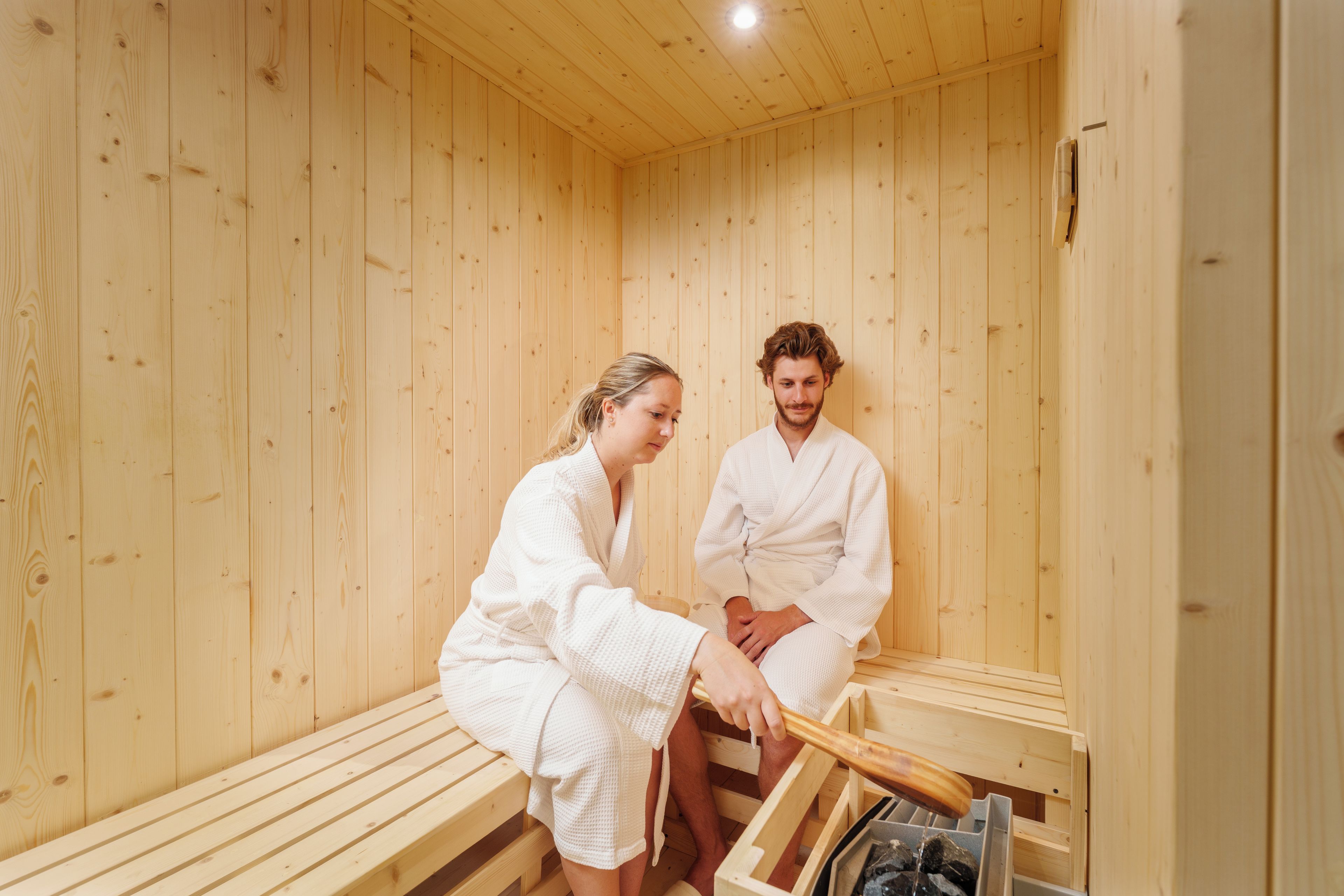 A sauna room with wooden walls and benches.