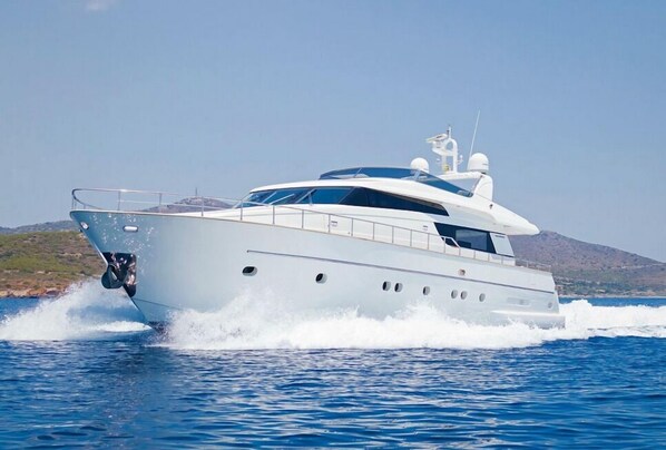 En stor lyxyacht med ett övre däck som är delvis täckt, ett kabinutrymme och en landningsplats för helikopter.