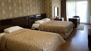 A hotel room with two beds, a desk, a chair, a mirror, and a window with curtains. - Aydın Park Otel (Aydin)
