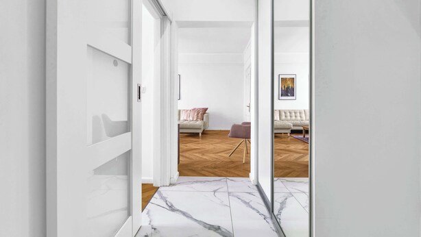 A modern interior with a marble floor leading to a living area with a sofa and a coffee table. - Trendy Apartment in Centrum 1 (Bratislavský kraj)
