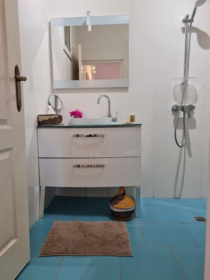Een douche, handdoeken, zeep, shampoo