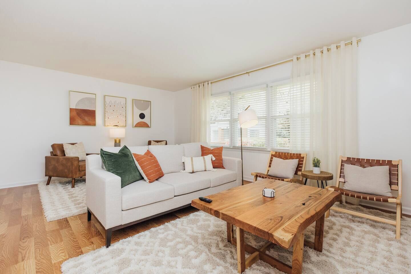 A modern living room with a white sofa, a wooden coffee table, and a small side table.