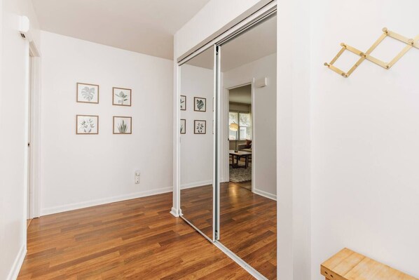 A room with wooden flooring, white walls, and a sliding door leading to another room. There are framed botanical prints on the wall. - Private Pool Oasis | 4BR Near Downtown Perry (Perry)