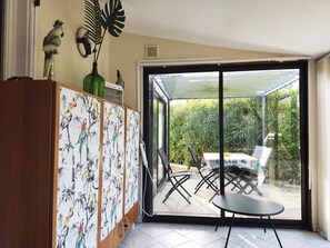Enjoy a serene garden view from the comfort of your room, featuring a dining area and a beautifully decorated cabinet.
