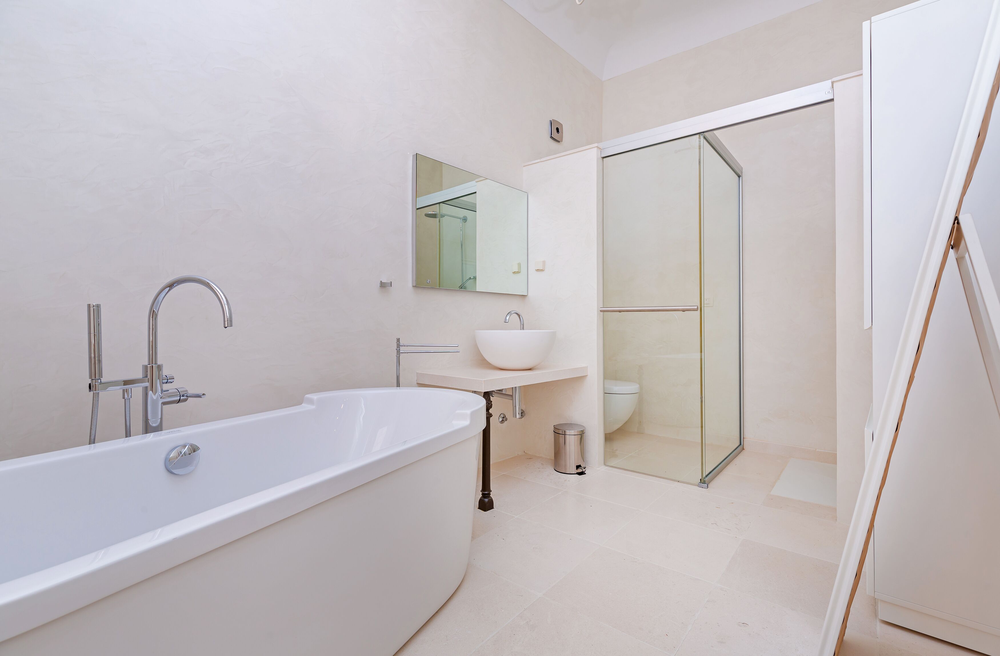 Un baño moderno con una bañera independiente, un lavamanos y una ducha con paredes de vidrio.