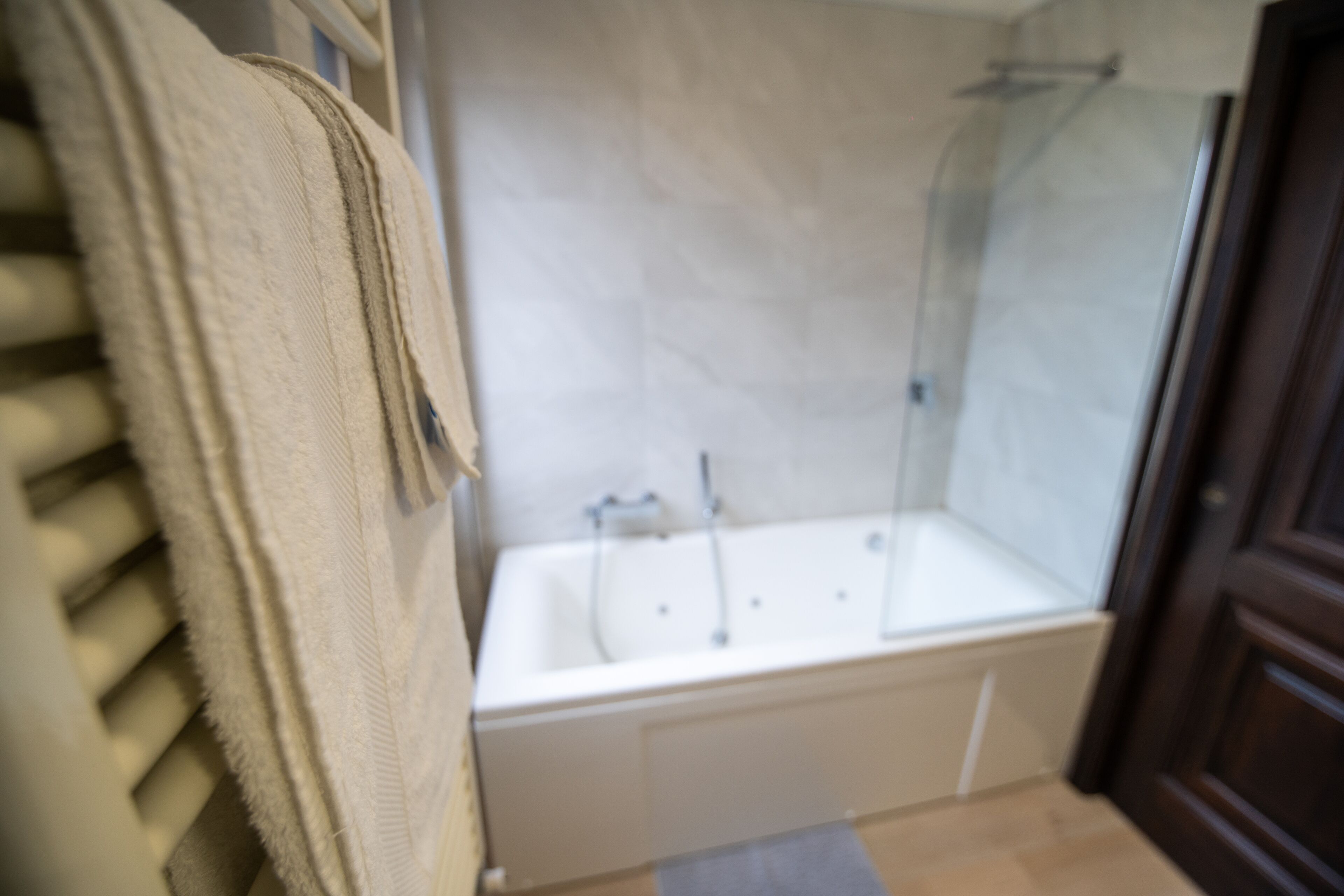 A bathroom with a bathtub, a shower, and a towel rack.