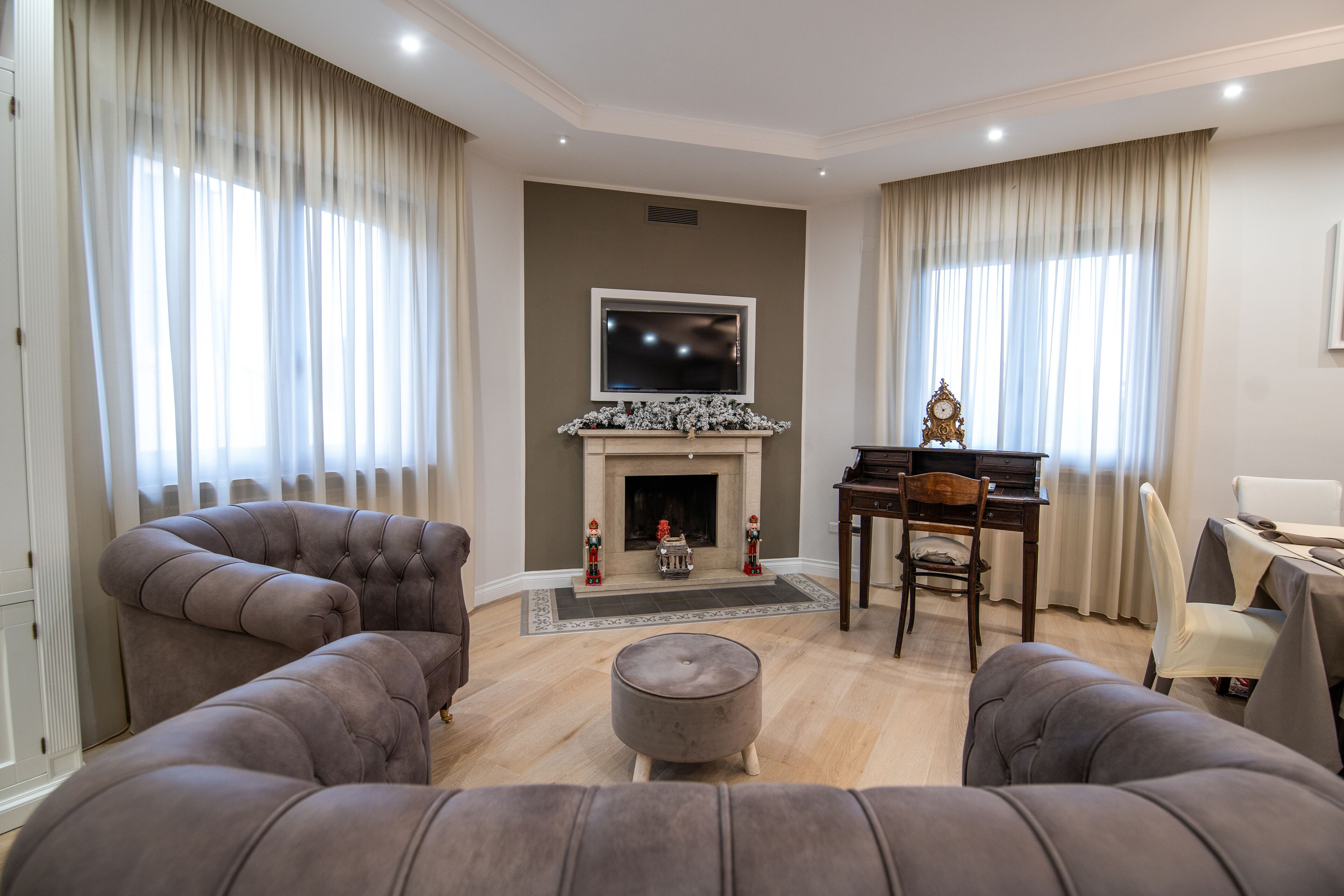 A living room with a fireplace, two sofas, a coffee table, and a piano.