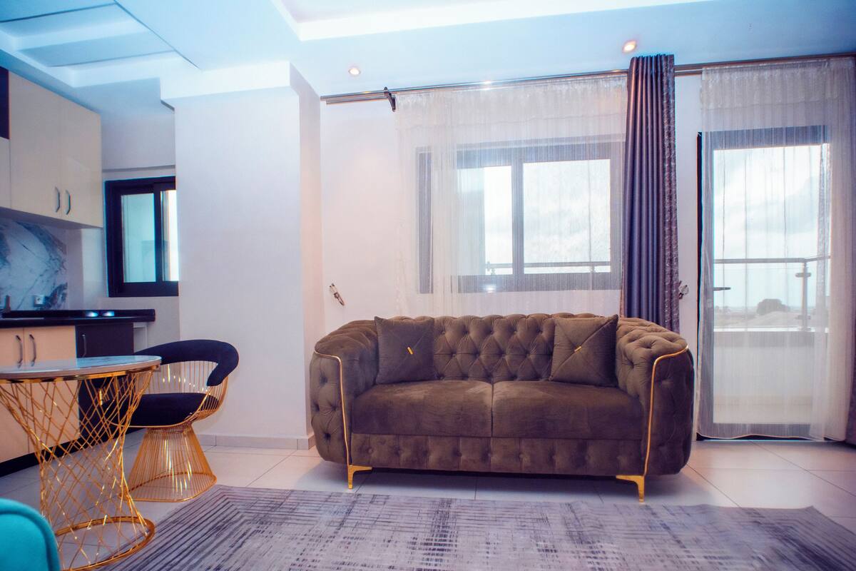 A modern living room with a brown sofa, a round coffee table, and a TV.