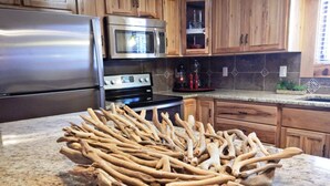 Eine Küche mit Holzschränken, Edelstahlgeräten und einer Arbeitsplatte aus Granit.