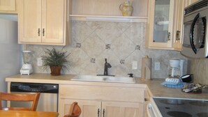 A kitchen with wooden cabinets, a sink, a microwave, a coffee maker, and a blender. - Mountain Harbor two bedroom Lodge cottage by RedAwning (Mount Ida)