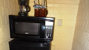 A compact kitchenette with a black refrigerator, a microwave, and a coffee maker. - King Guest Room located at the Joplin Inn at the entrance to Mountain Harbor, just 2 1/2 miles from Lake Ouachita. by RedAwning (Mount Ida)