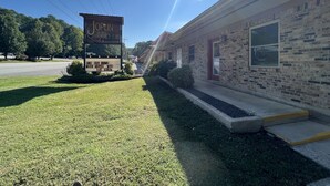 A motel with a sign advertising Lake Cozy Rooms with coffee and WiFi.