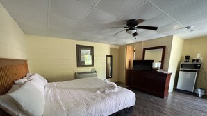 A hotel room with a bed, a ceiling fan, a television, a microwave, and a small kitchenette. - JI4, King Guest Room at the Joplin Inn at entrance to the resort by RedAwning (Mount Ida)