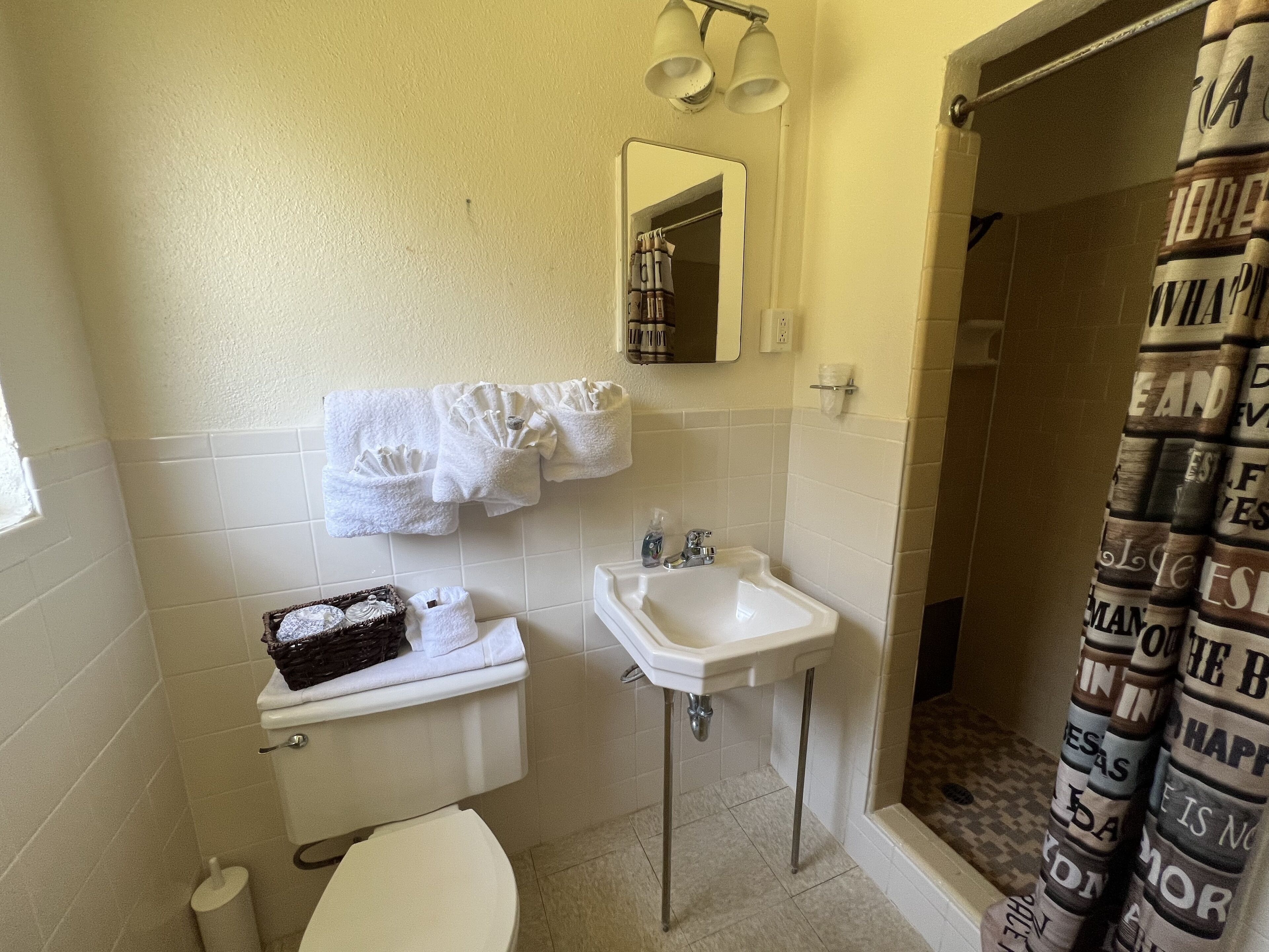 Un baño pequeño con inodoro, lavamanos y toallero.
