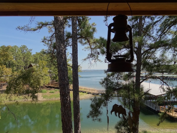 A view of a lake with trees and a wooden bridge.