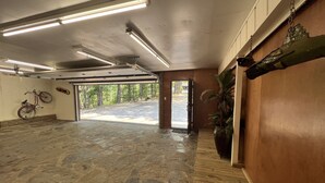 A spacious indoor area with a stone floor, a bicycle, and a potted plant. - Mountain Harbor's four bedroom house by RedAwning (Mount Ida)