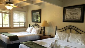 A hotel room with two beds, a ceiling fan, a window with blinds, a framed picture on the wall, and a lamp on the nightstand. - Mountain Harbor Forest View Lodge cottage by RedAwning (Mount Ida)